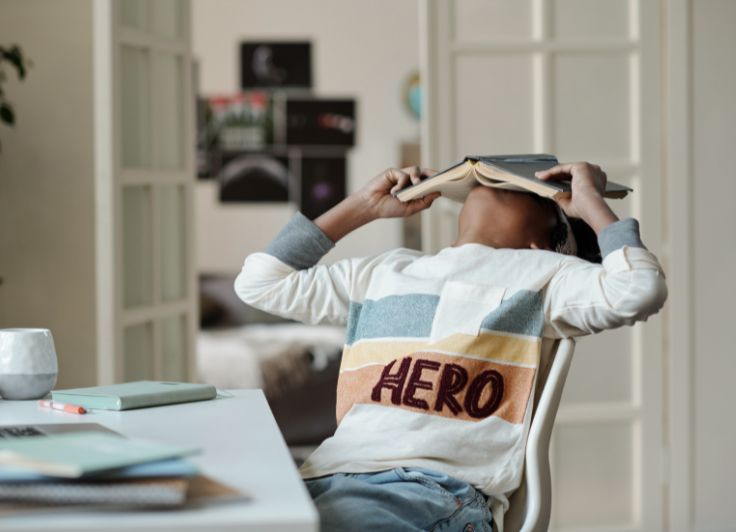 本に頭をうずめている男の子