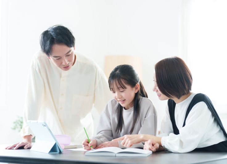 女子学生と勉強を見守る両親