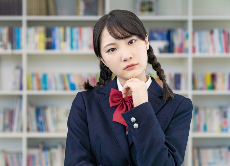 首を傾げる女子学生