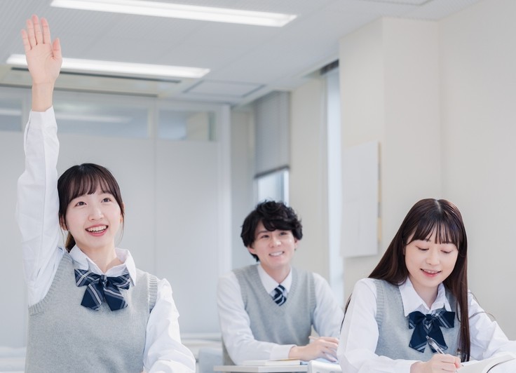 挙手する女子学生