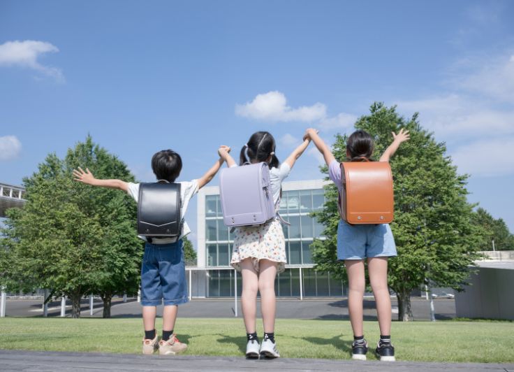 ランドセルを背負った3人の小学生の後ろ姿