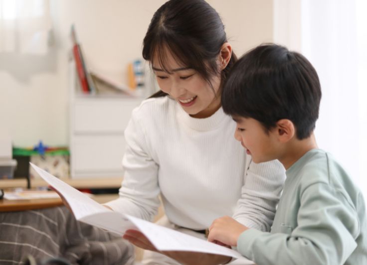 一緒に紙を見る親子