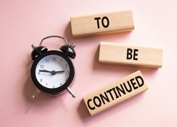 TOBECONTINUEDと書かれた木のブロックと黒い時計