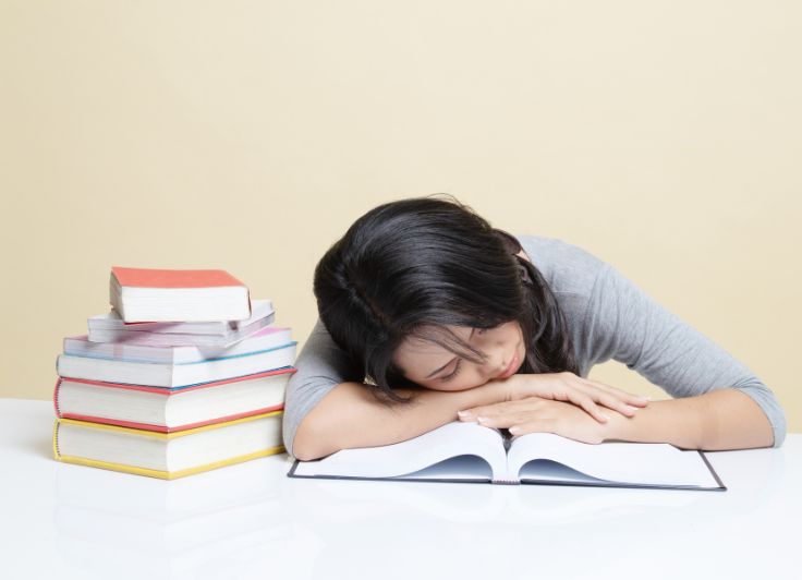 机に伏せている女子学生