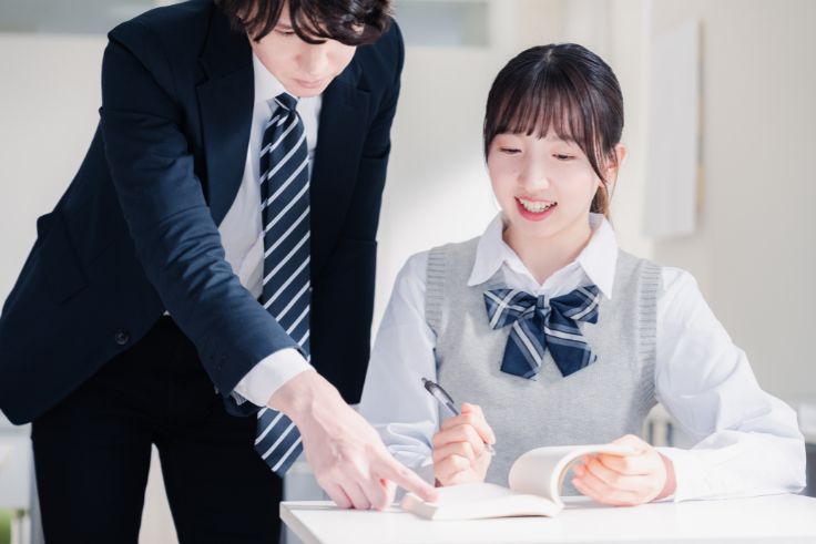 先生から勉強を教わる女子学生