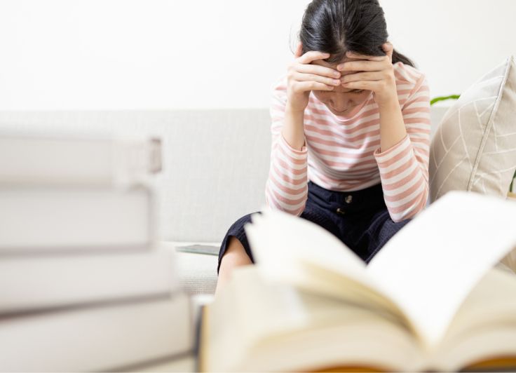 参考書と悩む少女