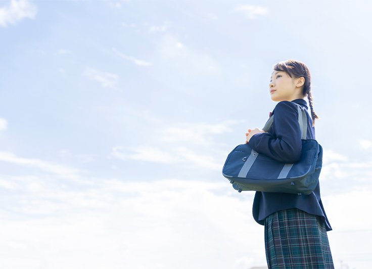 青空の下立っている学生