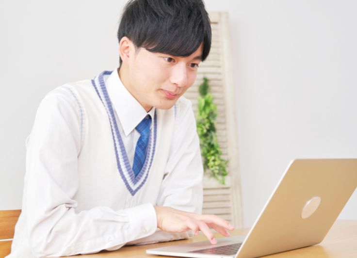 自宅で勉強する男子学生