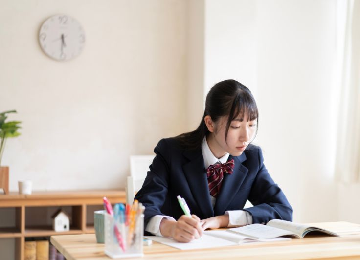 家で勉強している女子学生