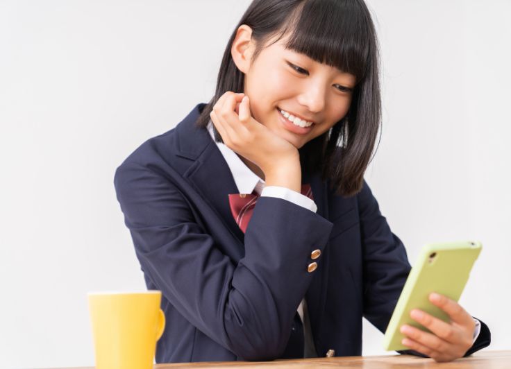 スマホを見る女子高生