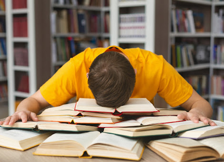 教科書の上に頭を置いて寝てる人
